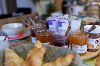 a table with food and jars of jam and bread at The Guest House in Vallorcine