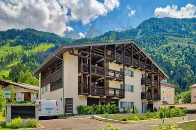 a apartment building with mountains in the background at Base Camp: Residence Ferme de Montenvers in Chamonix-Mont-Blanc