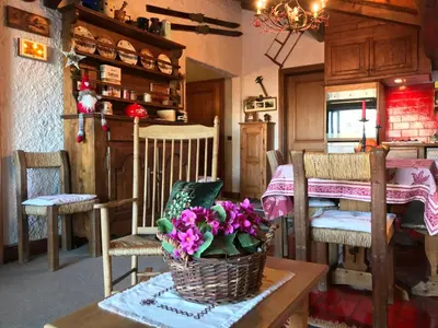 a room with a table with a basket of flowers on it at Appartement Hameau des Pistes - Ski-in and Ski-out in Megève