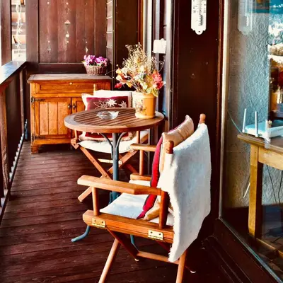 a table and chairs on a porch with a table and a table at Appartement Hameau des Pistes - Ski-in and Ski-out in Megève