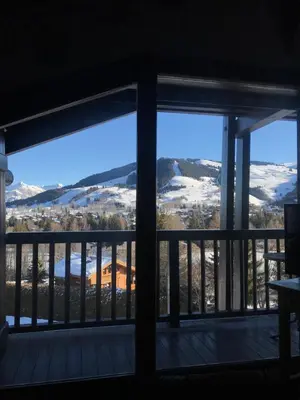 a view from the living room window of the snow covered mountains at Appartement Hameau des Pistes - Ski-in and Ski-out in Megève