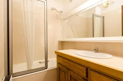 a small kitchen with wooden cabinets and white appliances at Appartement Le Chamois in Megève