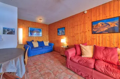 a living room with a red couch and a blue couch at Carabiner: Residence Espace Montagne in Chamonix-Mont-Blanc