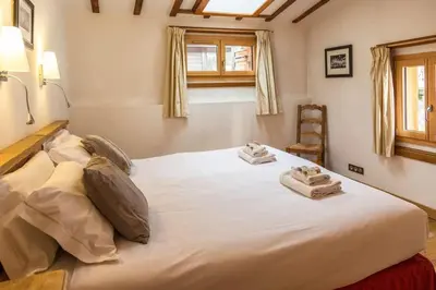 a large white bed in a room with a chair at Chalet Grand Cru in Chamonix-Mont-Blanc