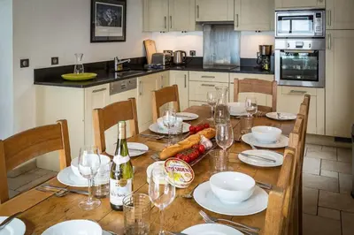 a kitchen with a wooden table with plates and wine glasses at Chalet Grand Cru in Chamonix-Mont-Blanc