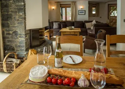 a table with a bottle of wine and a plate of food at Chalet Grand Cru in Chamonix-Mont-Blanc