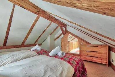 a bedroom with two beds and a wooden dresser at Chalet Heidi in Chamonix-Mont-Blanc