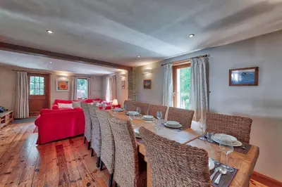 a dining room with a long table and a red couch at Chalet Heidi in Chamonix-Mont-Blanc