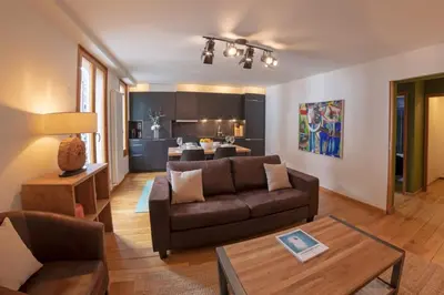 a living room with a couch and a table at Paccard: Residence Le Lutetia in Chamonix-Mont-Blanc