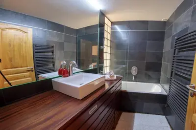 a bathroom with a large white sink and a tub at Paccard: Residence Le Lutetia in Chamonix-Mont-Blanc