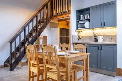 a kitchen and dining room with a wooden table and chairs at Skyhook: Batiment B in Chamonix-Mont-Blanc