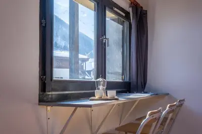 a window with two chairs and a glass vase on it at Skyhook: Batiment B in Chamonix-Mont-Blanc