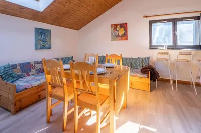 a living room with a table and chairs and a couch at Skyhook: Batiment B in Chamonix-Mont-Blanc