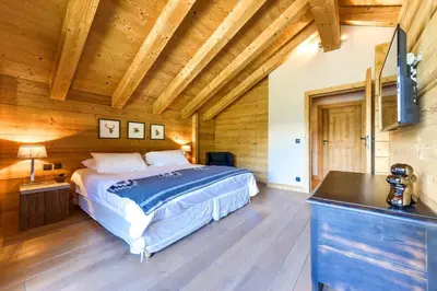 a bedroom with a bed in a room with wooden ceilings at Chalet Noemie in Les Houches