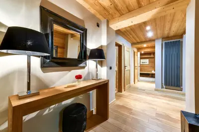 a hallway with a desk with two lamps and a mirror at Chalet Noemie in Les Houches