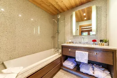 a bathroom with a tub and a sink and a mirror at Chalet Noemie in Les Houches