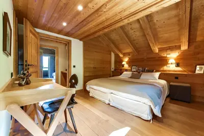 a bedroom with a large bed and a desk at Chalet Noemie in Les Houches