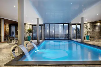 a large swimming pool in a building with windows at Chalet Noemie in Les Houches