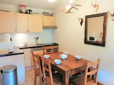 a kitchen with a wooden table with bowls on it at Appartement confortable près des pistes avec balcon et Wi-Fi - FR-1-815-67 in Morillon