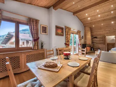 a dining room with a wooden table and a large window at Appartement 3 chambres rénové à Megève - FR-1-453-6 in Megève