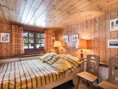 a bedroom with a bed and a wooden wall at Chalet 4 chambres à Megève Mont d'Arbois - 10 pers, terrasse, parking - FR-1-453-10 in Megève