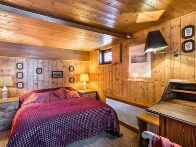 a bedroom with a bed and a wooden wall at Chalet 4 chambres à Megève Mont d'Arbois - 10 pers, terrasse, parking - FR-1-453-10 in Megève