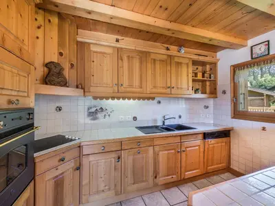 a kitchen with wooden cabinets and a sink at Appartement 4 chambres à Megève avec Wi-Fi et garage - FR-1-453-11 in Megève