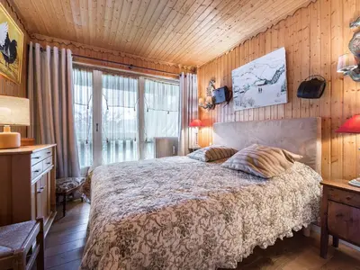 a bedroom with a bed in a room with wooden walls at Appartement confortable 3 chambres proche centre Megève, balcon, cheminée, 8 pers. - FR-1-453-14 in Megève