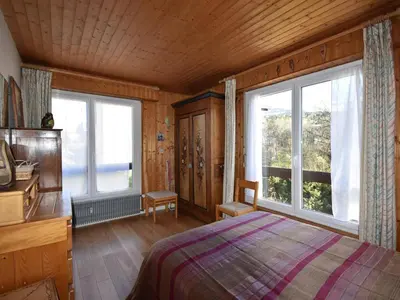 a bedroom with a bed and two large windows at Appartement confortable 3 chambres proche centre Megève, balcon, cheminée, 8 pers. - FR-1-453-14 in Megève
