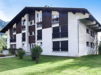 a large building with a grass yard in front of it at Appartement confortable 3 chambres proche centre Megève, balcon, cheminée, 8 pers. - FR-1-453-14 in Megève