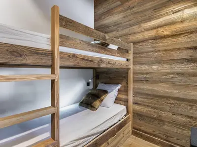 a bedroom with two bunk beds with wooden walls at Superbe duplex à Megève pour 7 pers., parking - FR-1-453-25 in Megève