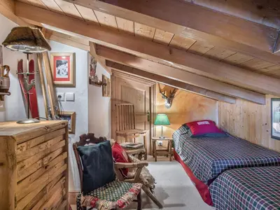 a bedroom with two beds and a chair in a room at Appartement 3 chambres Megève Sud avec Balcon et Wifi - FR-1-453-28 in Megève