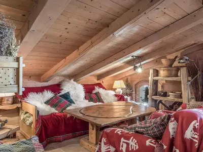 a living room with a red couch and a wooden table at Appartement 3 chambres Megève Sud avec Balcon et Wifi - FR-1-453-28 in Megève