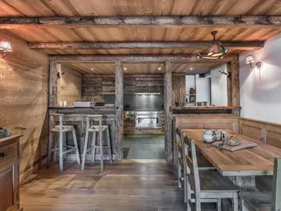 a kitchen with wooden walls and wooden tables and stools at Bel Appartement 3 Chambres à Megève, Terrasse, Wifi - FR-1-453-35 in Megève