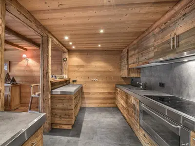 a kitchen with wooden walls and a stove top oven at Bel Appartement 3 Chambres à Megève, Terrasse, Wifi - FR-1-453-35 in Megève