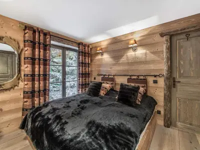 a bedroom with a large bed in a room with wooden walls at Bel Appartement 3 Chambres à Megève, Terrasse, Wifi - FR-1-453-35 in Megève