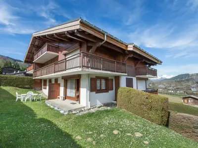 a house with a balcony on top of a field at Appartement 3 pièces Megève - Animaux admis, Parking inclus - FR-1-453-38 in Megève
