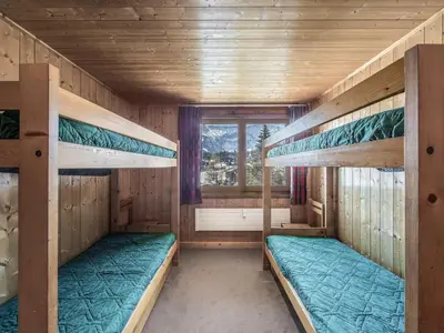 two bunk beds in a room with a window at Appartement cosy 2 chambres avec wifi à Megève - FR-1-453-48 in Megève