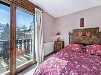 a bedroom with a bed and a large window at Appartement cosy 2 chambres avec wifi à Megève - FR-1-453-48 in Megève
