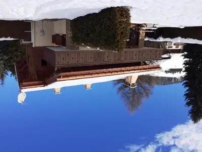 a reflection of a building in the water at Duplex 3 Chambres à Megève - Confort et Wifi - FR-1-453-49 in Megève