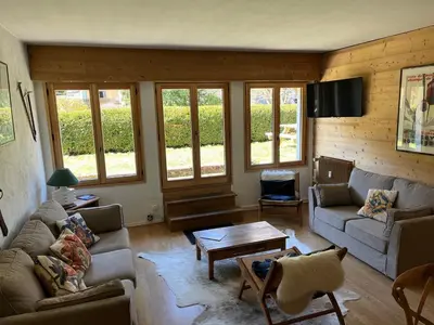 a living room with couches and a table and windows at Appartement cosy 2 chambres, terrasse et parking à Megève - FR-1-453-52 in Megève