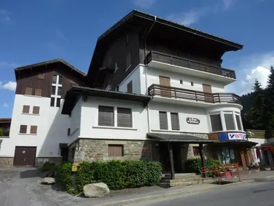 a large white building with a black roof at Appartement cosy 2 chambres, terrasse et parking à Megève - FR-1-453-52 in Megève