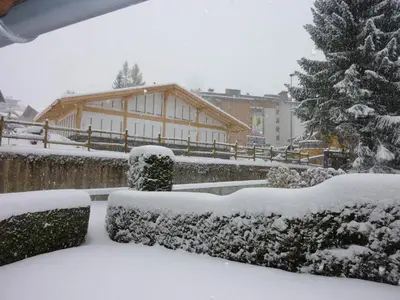 a snow covered yard with a building and a christmas tree at Appartement cosy 2 chambres, terrasse et parking à Megève - FR-1-453-52 in Megève