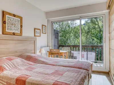 a bedroom with a bed and a large window at Appartement 2 pièces à Megève, balcon au sud, proche centre - FR-1-453-54 in Megève