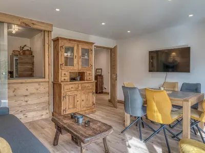 a living room with a table and yellow chairs at Appartement 2 pièces à Megève, balcon au sud, proche centre - FR-1-453-54 in Megève