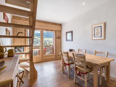 a kitchen and dining room with a wooden table and chairs at Appartement 1 chambre et mezzanine à Megève avec balcon et animaux admis - FR-1-453-57 in Megève
