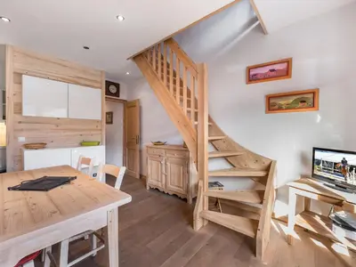 a wooden staircase in a room with a table and a desk at Appartement 1 chambre et mezzanine à Megève avec balcon et animaux admis - FR-1-453-57 in Megève