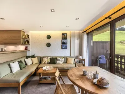 a living room with a couch and a table at Studio skis aux pieds à Megève, animaux permis - FR-1-453-58 in Megève