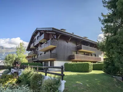 an apartment building with a garden in front of it at Studio skis aux pieds à Megève, animaux permis - FR-1-453-58 in Megève