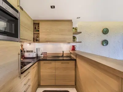 a kitchen with wooden cabinets and a counter top at Studio skis aux pieds à Megève, animaux permis - FR-1-453-58 in Megève